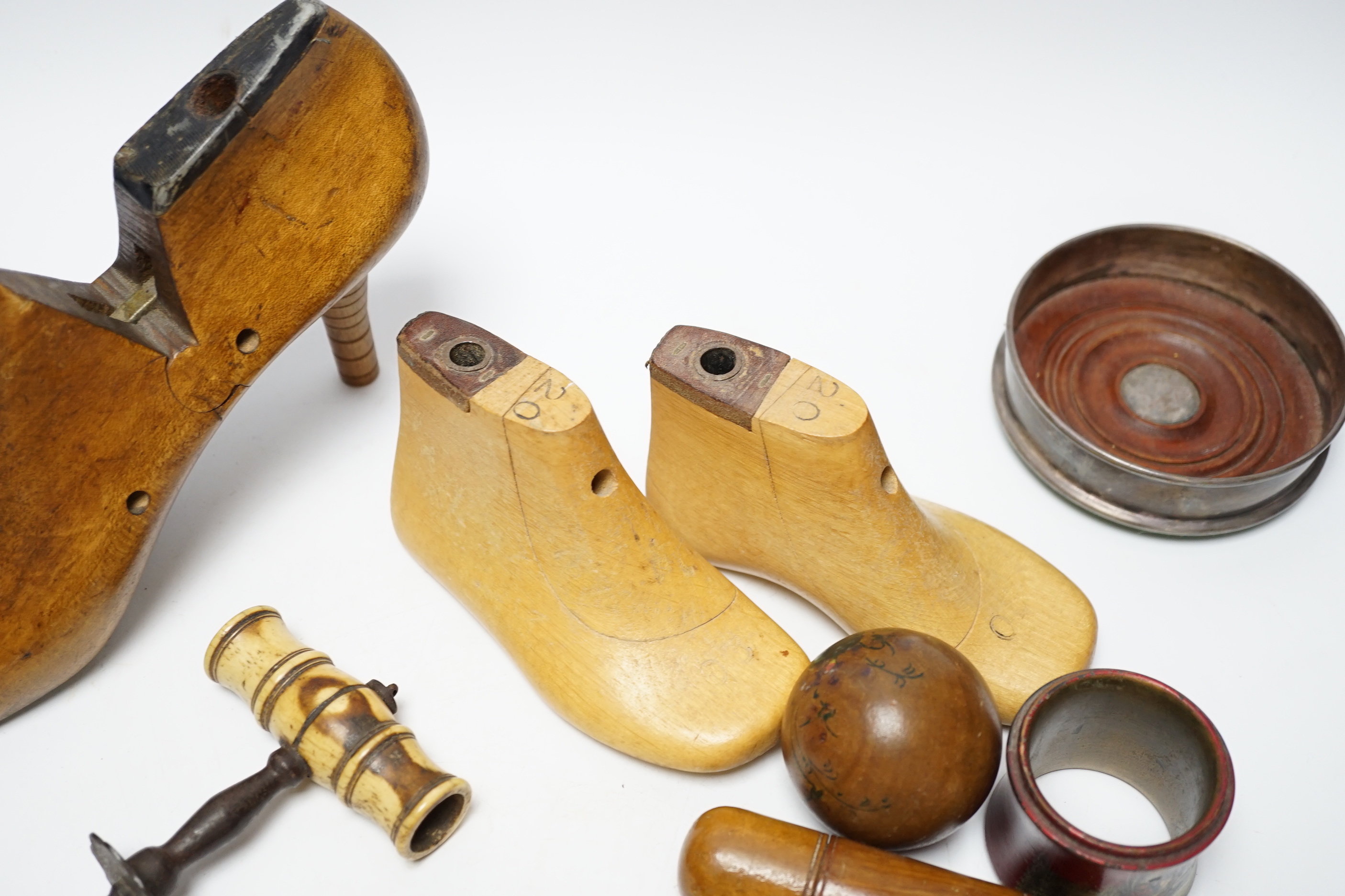 Treen: a ladies stiletto shoe last, a pair of children’s shoe lasts, a novelty foot ashtray, two lacquered napkin rings with painted Russian scenes, a bone handled cork screw etc (14)